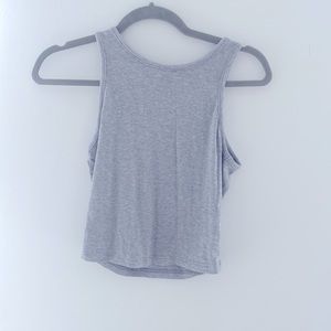 Light-medium grey tank top that is short but not cropped.